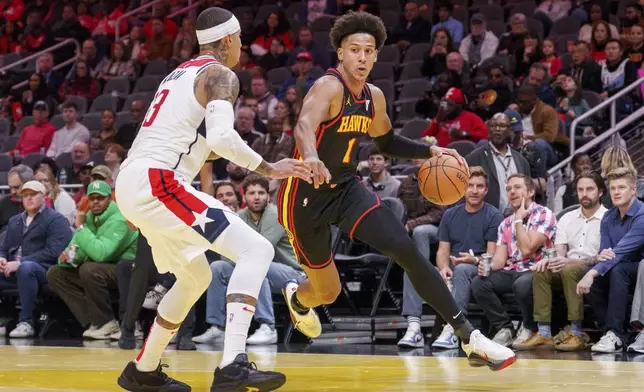 Atlanta Hawks forward Jalen Johnson (1) drives the baseline while guarded by Washington Wizards forward Kyle Kuzma, left, during the first half of an Emirates NBA Cup basketball game, Friday, Nov. 15, 2024, in Atlanta. (AP Photo/Jason Allen)