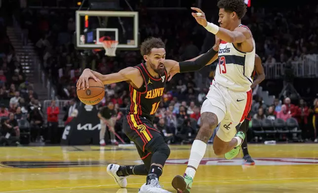 Atlanta Hawks guard Trae Young, left, dribbles while guarded by Washington Wizards guard Jordan Poole, right, during the first half of an Emirates NBA Cup basketball game, Friday, Nov. 15, 2024, in Atlanta. (AP Photo/Jason Allen)