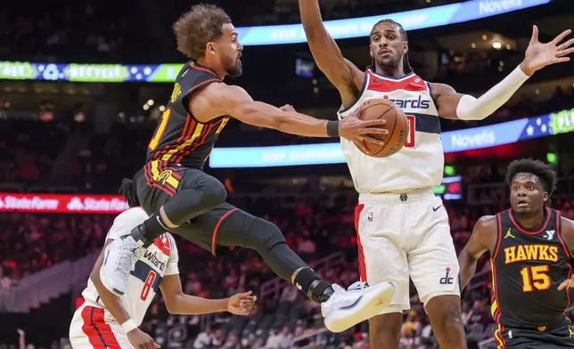 Atlanta Hawks guard Trae Young, left, attempts to pass to center Clint Capela (15) during the first half of an Emirates NBA Cup basketball game against the Washington Wizards, Friday, Nov. 15, 2024, in Atlanta. (AP Photo/Jason Allen)