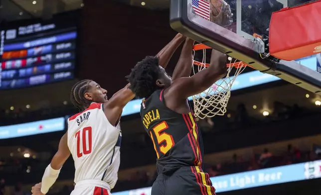 Atlanta Hawks center Clint Capela, right, goes up for a slam dunk guarded by Washington Wizards forward Alexandre Sarr, left, during the first half of an Emirates NBA Cup basketball game, Friday, Nov. 15, 2024, in Atlanta. (AP Photo/Jason Allen)