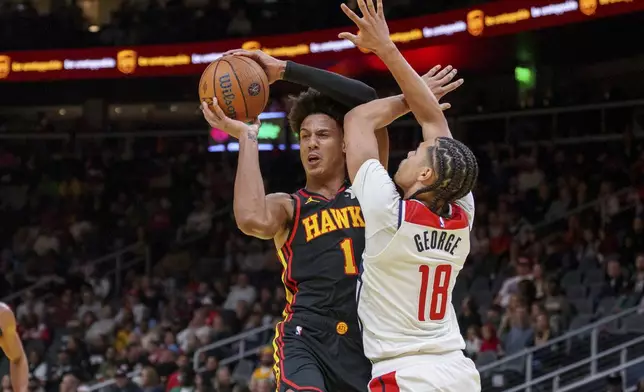 Atlanta Hawks forward Jalen Johnson (1) gets the rebound over Washington Wizards forward Kyshawn George (18) during the first half of an Emirates NBA Cup basketball game, Friday, Nov. 15, 2024, in Atlanta. (AP Photo/Jason Allen)