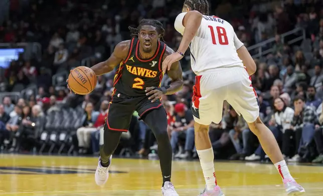 Atlanta Hawks guard Keaton Wallace (2) looks for an open teammate while guarded by Washington Wizards forward Kyshawn George (18) during the first half of an Emirates NBA Cup basketball game, Friday, Nov. 15, 2024, in Atlanta. (AP Photo/Jason Allen)