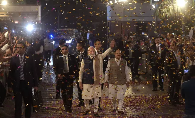 Bharatiya Janata Party supporters shower confetti and flower petals as Indian prime minister Narendra Modi, center, arrives to address them at the party headquarters after wining the state elections in politically significant Indian state of Maharashtra, in New Delhi, India, Saturday, Nov. 23, 2024. (AP Photo)