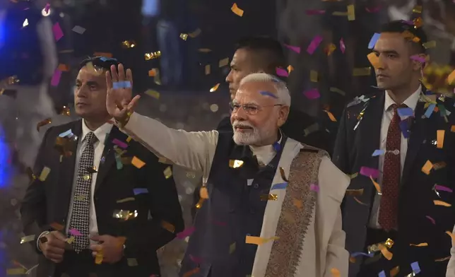 Bharatiya Janata Party supporters shower confetti and flower petals as Indian prime minister Narendra Modi, center, arrives to address them at the party headquarters after wining the state elections in politically significant Indian state of Maharashtra, in New Delhi, India, Saturday, Nov. 23, 2024. (AP Photo)