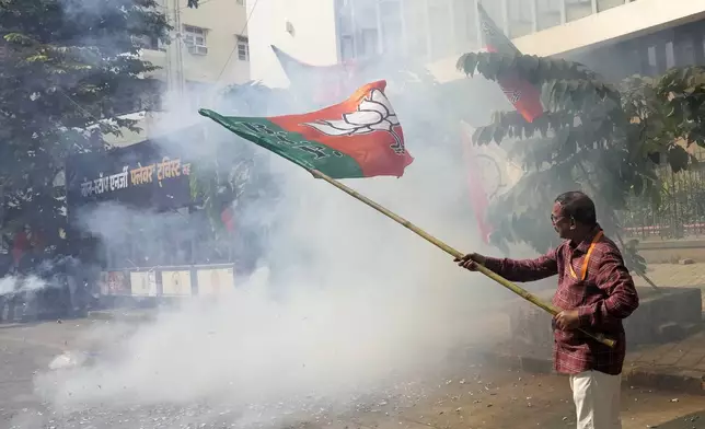 Bhartiya Janata Party worker celebrates after leading in Maharashtra state assembly elections outside party office in Mumbai, India, Saturday, Nov 23, 2024. (AP Photo/Rajanish Kakade)