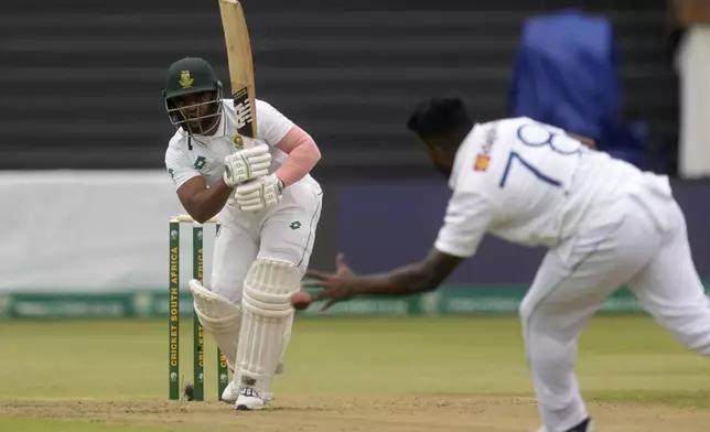 South Africa's captain Temba Bavuma, left, watches on as Sri Lanka's Asitha Fernando attempt a catch during day one of the first Test cricket match between South Africa and Sri Lanka, at Kingsmead stadium in Durban, South Africa, Wednesday, Nov. 27, 2024. (AP Photo/Themba Hadebe)