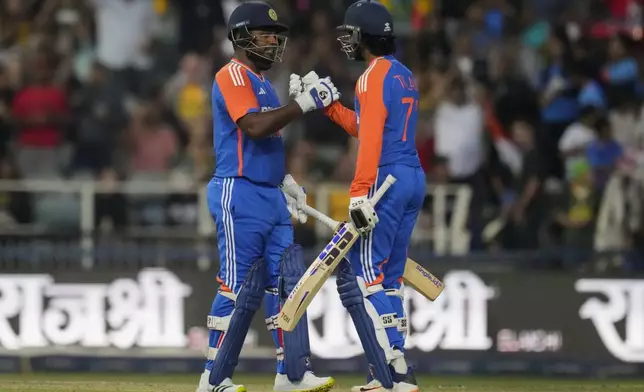 India's Sanju Samson, left, celebrates with batting partner Tilak Varma after scoring a century during the fourth T20 cricket match between South Africa and India at the Wanderers Stadium in Johannesburg, South Africa, Friday, Nov. 15, 2024. (AP Photo/Themba Hadebe)