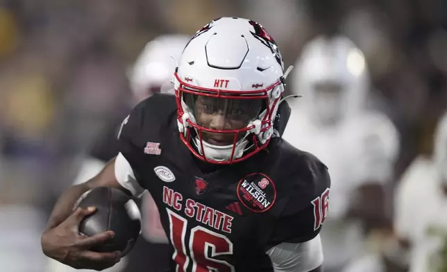 North Carolina State quarterback CJ Bailey (16) runs the ball in for a touchdown during the first half of an NCAA college football game against Georgia Tech, Thursday, Nov. 21, 2024, in Atlanta. (AP Photo/Brynn Anderson)