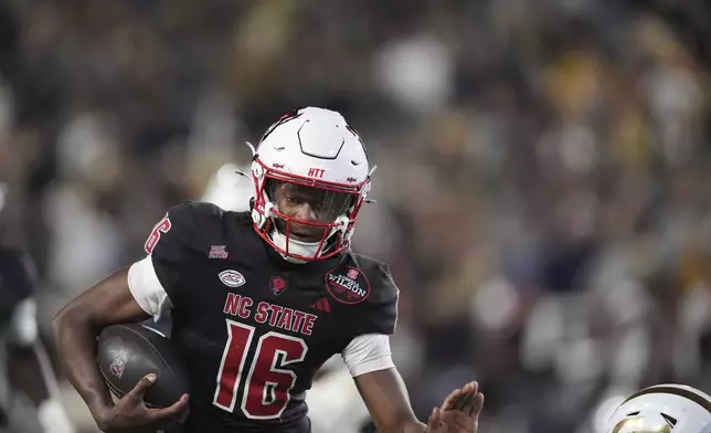 North Carolina State quarterback CJ Bailey (16) runs the ball in for a touchdown during the first half of an NCAA college football game against Georgia Tech, Thursday, Nov. 21, 2024, in Atlanta. (AP Photo/Brynn Anderson)