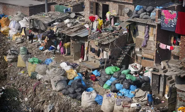 People store various waste materials in plastic sacks for sorting out in New Delhi, India, Tuesday, Nov. 26, 2024. (AP Photo/Manish Swarup)