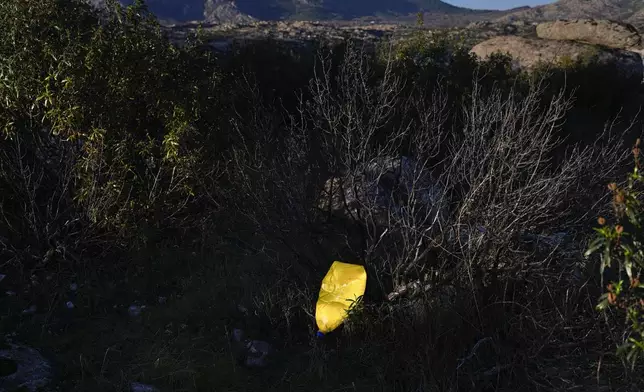 A plastic bottle is stuck in a bush in Valdemanco, outskirts of Madrid, on Wednesday, Nov. 27, 2024. (AP Photo/Bernat Armangue)