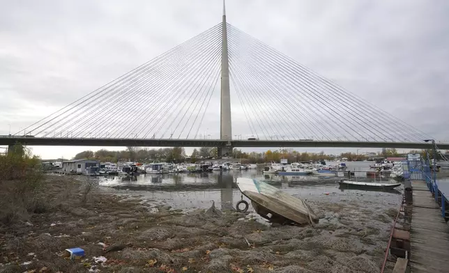 An abandoned plastic boat lies on a dry bank of the Sava river in Belgrade, Serbia, Tuesday, Nov. 26, 2024. (AP Photo/Darko Vojinovic)