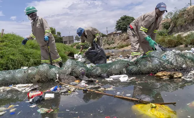 Alexandra Water Warriors volunteers cleanup the Juksei river in the heart of Alexandra township from plastic pollution in Johannesburg, South Africa, Wednesday, Nov. 27, 2024. (AP Photo/Jerome Delay)