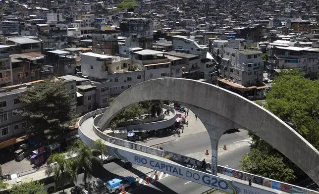 A pedestrian bridge leading to the Rocinha favela is covered by a sign that says in Portuguese: "Rio capital of the G20," in Rio de Janeiro, Wednesday, Nov. 6, 2024, ahead of the G20 Leaders' Summit. (AP Photo/Bruna Prado)