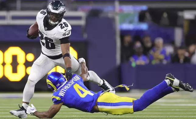 Philadelphia Eagles running back Saquon Barkley (26) runs against Los Angeles Rams cornerback Ahkello Witherspoon (4) during the second half of an NFL football game in Inglewood, Calif., Sunday, Nov. 24, 2024. (AP Photo/Ryan Sun)