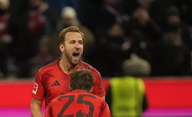 Bayern's Harry Kane, left, celebrates after scoring his side's second goal with a penalty kick during the Bundesliga soccer match between Bayern Munich and Augsburg at the Allianz Arena in Munich, Germany, Friday, Nov. 22, 2024. (AP Photo/Matthias Schrader)