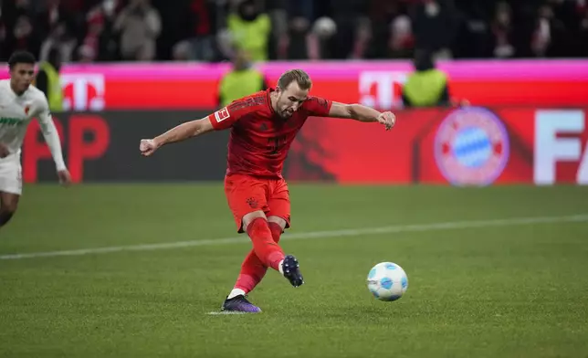 Bayern's Harry Kane, kicks a penalty to score his side's second goal during the Bundesliga soccer match between Bayern Munich and Augsburg at the Allianz Arena in Munich, Germany, Friday, Nov. 22, 2024. (AP Photo/Matthias Schrader)