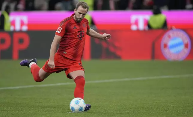 Bayern's Harry Kane, kicks a penalty to score his side's second goal during the Bundesliga soccer match between Bayern Munich and Augsburg at the Allianz Arena in Munich, Germany, Friday, Nov. 22, 2024. (AP Photo/Matthias Schrader)