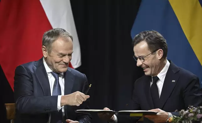 Poland's Prime Minister Donald Tusk, left, and Sweden's Prime Minister Ulf Kristersson sign an agreement during Thursday's summit at Harpsund in Flen, Sweden, Thursday, Nov. 28, 2024. (Henrik Montgomery/TT News Agency via AP)