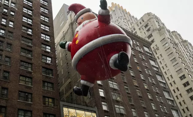 Handlers guide a Santa Claus balloon down Sixth Avenue during the Macy's Thanksgiving Day Parade, Thursday, Nov. 28, 2024, in New York. (AP Photo/Julia Demaree Nikhinson)