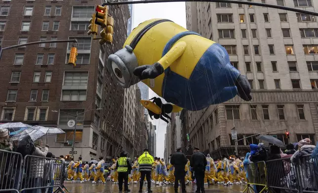 Handlers pull the Stuart the Minion balloon down Sixth Avenue during the Macy's Thanksgiving Day Parade, Thursday, Nov. 28, 2024, in New York. (AP Photo/Julia Demaree Nikhinson)