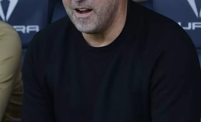 Barcelona's head coach Hansi Flick waits for the beginning of the the Spanish La Liga soccer match against Las Palmas at the Lluis Companys Olympic Stadium in Barcelona, Spain, Saturday Nov. 30, 2024. (AP Photo/Joan Monfort)