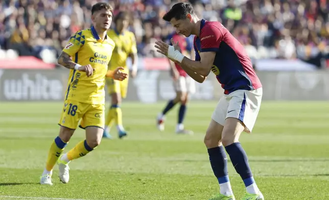 Barcelona's Robert Lewandowski, right, reacts after missing a chance to score a goal against Las Palmas during a Spanish La Liga soccer match at the Lluis Companys Olympic Stadium in Barcelona, Spain, Saturday Nov. 30, 2024. (AP Photo/Joan Monfort)