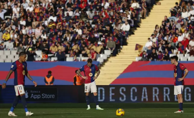 Barcelona's players react after the second goal of Las Palmas during a Spanish La Liga soccer match at the Lluis Companys Olympic Stadium in Barcelona, Spain, Saturday Nov. 30, 2024. (AP Photo/Joan Monfort)