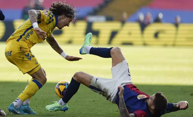 Las Palmas' Fabio Silva, left, and Barcelona's Inigo Martinez fight for the ball during a Spanish La Liga soccer match at the Lluis Companys Olympic Stadium in Barcelona, Spain, Saturday Nov. 30, 2024. (AP Photo/Joan Monfort)