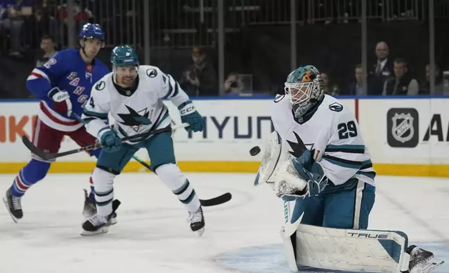 San Jose Sharks goaltender Mackenzie Blackwood, right, make a save during the second period of an NHL hockey game against the New York Rangers, Thursday, Nov. 14, 2024, in New York. (AP Photo/Seth Wenig)