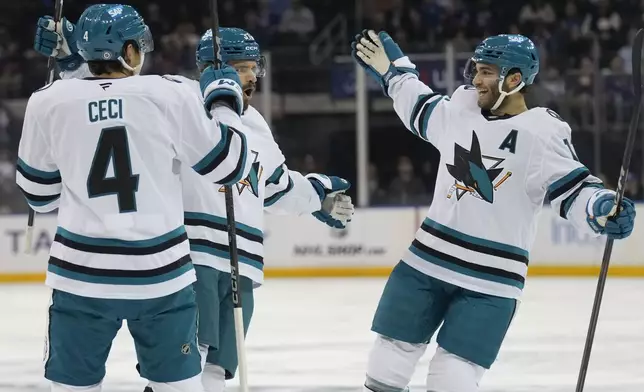 San Jose Sharks' Timothy Liljegren, center, celebrates his goal with Cody Ceci, left, and Luke Kunin during the first period of an NHL hockey game against the New York Rangers, Thursday, Nov. 14, 2024, in New York. (AP Photo/Seth Wenig)