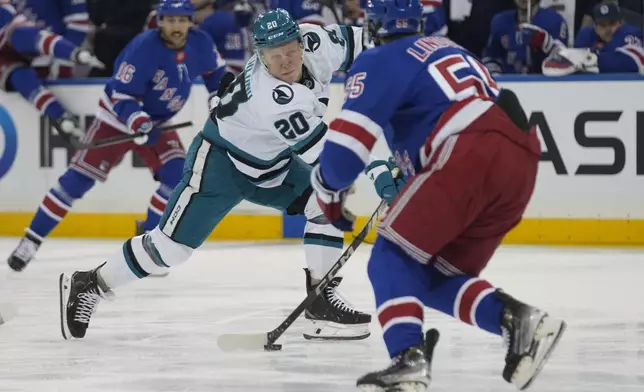 San Jose Sharks' Fabian Zetterlund (20), left, shoots on goal during the first period of an NHL hockey game against the New York Rangers, Thursday, Nov. 14, 2024, in New York. (AP Photo/Seth Wenig)