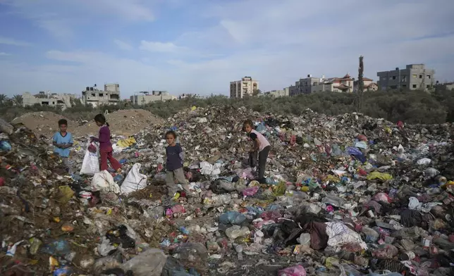 Palestinian kids sort through trash at a landfill in Zawaida, Gaza Strip, Sunday, Nov. 17, 2024. (AP Photo/Abdel Kareem Hana)