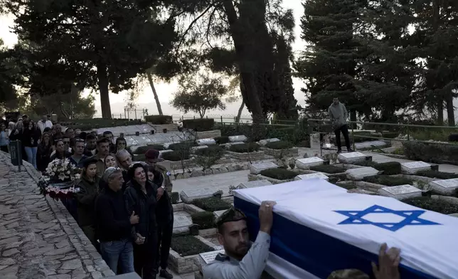 The family of Israeli Defense Forces Sgt. First Class (res.) Roi Sasson, who was killed in action in the Gaza Strip, walk behind his coffin during his funeral at Mt. Herzl military cemetery in Jerusalem, Wednesday, Nov. 20, 2024. (AP Photo/Maya Alleruzzo)