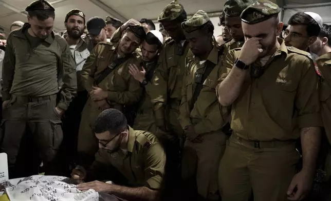 Israeli Defense Forces soldiers mourn at the grave of Sgt. First Class (res.) Roi Sasson, who was killed in action in the Gaza Strip, during his funeral at Mt. Herzl military cemetery in Jerusalem, Wednesday, Nov. 20, 2024. (AP Photo/Maya Alleruzzo)