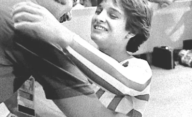 FILE - Mary Lou Retton of the USA is hugged by her coach, Bela Karolyi, following her perfect performance in the floor exercise in Olympic individual all-around finals, Aug. 3, 1984, in Los Angeles. (AP Photo/Sadayuki Mikami, File)