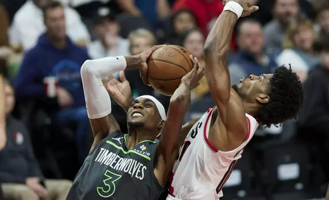 Minnesota Timberwolves forward Jaden McDaniels, left, shoots over Portland Trail Blazers guard Scoot Henderson during the second half of an NBA basketball game in Portland, Ore., Wednesday, Nov. 13, 2024. (AP Photo/Craig Mitchelldyer)