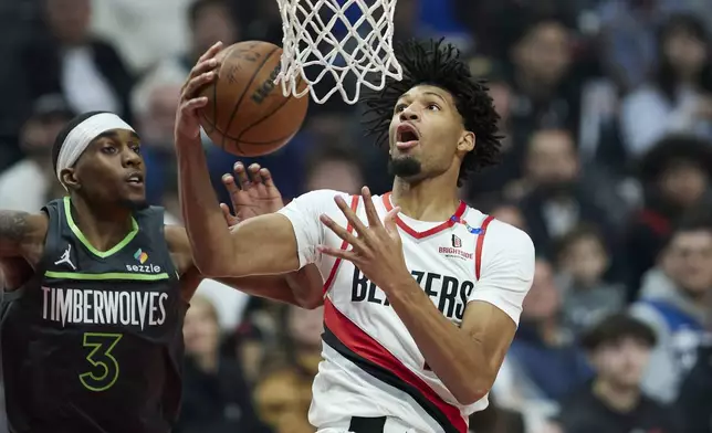 Portland Trail Blazers guard Shaedon Sharpe, right, shoots over Minnesota Timberwolves forward Jaden McDaniels during the first half of an NBA basketball game in Portland, Ore., Wednesday, Nov. 13, 2024. (AP Photo/Craig Mitchelldyer)