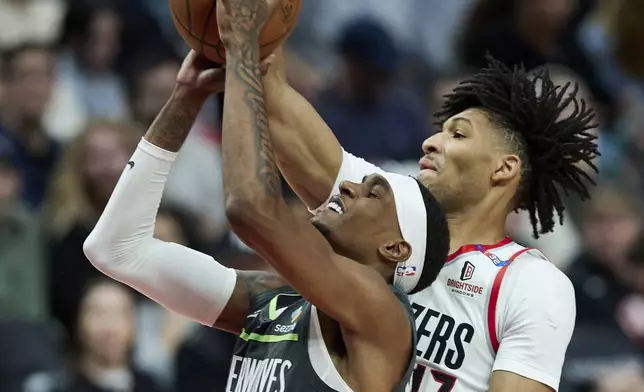 Minnesota Timberwolves forward Jaden McDaniels, left, shoots over Portland Trail Blazers guard Shaedon Sharpe during the second half of an NBA basketball game in Portland, Ore., Wednesday, Nov. 13, 2024. (AP Photo/Craig Mitchelldyer)