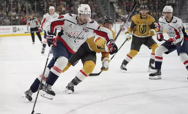 Washington Capitals center Connor McMichael (24) skates around Vegas Golden Knights defenseman Brayden McNabb (3) during the first period of an NHL hockey game Sunday, Nov. 17, 2024, in Las Vegas. (AP Photo/John Locher)