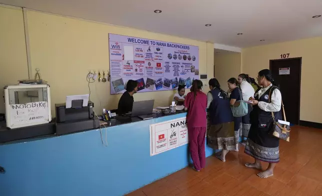 Health officials check documents and ask questions to Nana hostel employees in Vang Vieng, Laos, Friday, Nov. 22, 2024. (AP Photo/Anupam Nath)