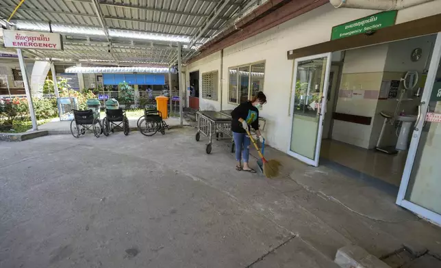 A woman cleans near the emergency section of a hospital where poisoned foreign tourists admitted in Vang Vieng, Laos, Friday, Nov. 22, 2024. (AP Photo/Anupam Nath)