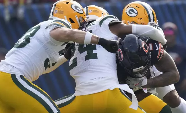 Chicago Bears' DJ Moore is stoped by Green Bay Packers' Xavier McKinney, Evan Williams and Carrington Valentine during the first half of an NFL football game Sunday, Nov. 17, 2024, in Chicago. (AP Photo/Nam Y. Huh)