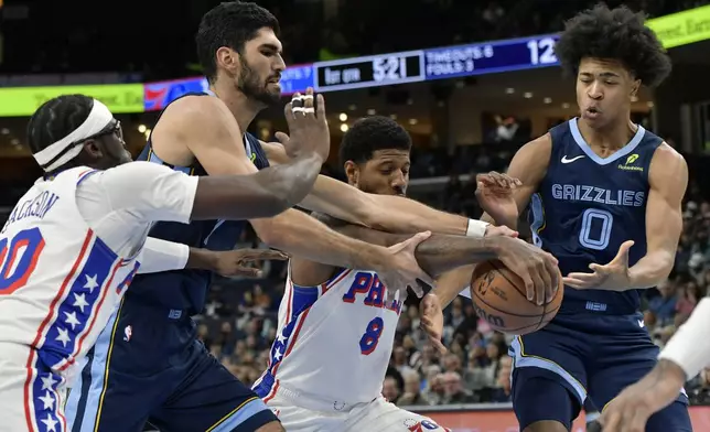 Philadelphia 76ers guard Reggie Jackson (00), Memphis Grizzlies forward Santi Aldama (7), forward Paul George (8), and forward Jaylen Wells (0) struggle for control of the ball in the first half of an NBA basketball game Wednesday, Nov. 20, 2024, in Memphis, Tenn. (AP Photo/Brandon Dill)