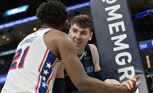 Philadelphia 76ers center Joel Embiid (21) and Memphis Grizzlies forward Jake LaRavia connect after a play in the second half of an NBA basketball game Wednesday, Nov. 20, 2024, in Memphis, Tenn. (AP Photo/Brandon Dill)