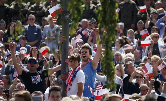 FILE - People cheer as US President Donald Trump delivers a speech at Krasinski Square at the Royal Castle, July 6, 2017, in Warsaw. (AP Photo/Evan Vucci, File)