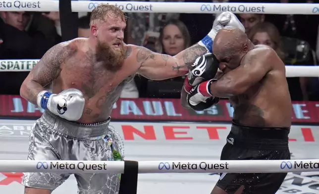 Jake Paul hits Mike Tyson during their heavyweight boxing match, Friday, Nov. 15, 2024, in Arlington, Texas. (AP Photo/Julio Cortez)