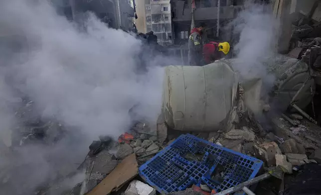 Rescue workers search for victims at the site of an Israeli airstrike that hit central Beirut, Lebanon, Saturday, Nov. 23, 2024. (AP Photo/Hussein Malla)