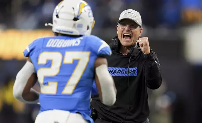 Los Angeles Chargers head coach Jim Harbaugh, right, celebrates after a rushing touchdown by running back J.K. Dobbins (27) during the first half of an NFL football game against the Cincinnati Bengals, Sunday, Nov. 17, 2024, in Inglewood, Calif. (AP Photo/Gregory Bull)