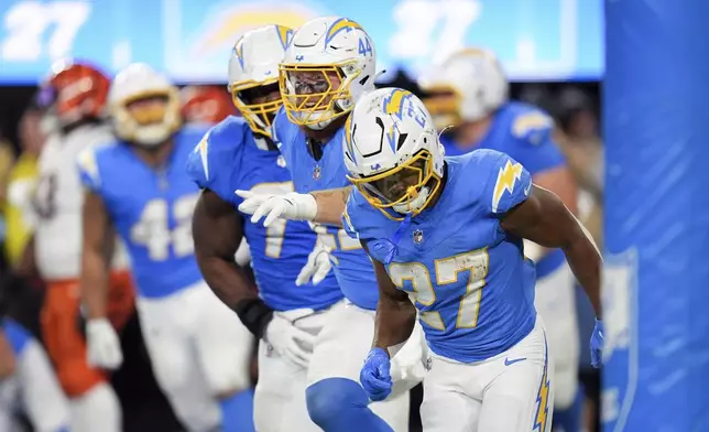 Los Angeles Chargers running back J.K. Dobbins (27) runs back to the bench after scoring a rushing touchdown during the second half of an NFL football game against the Cincinnati Bengals, Sunday, Nov. 17, 2024, in Inglewood, Calif. (AP Photo/Gregory Bull)